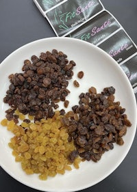 a plate with raisins, nuts, and a box