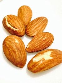 five almonds are sitting on a white plate