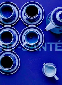 a set of blue cups and saucers on a blue surface