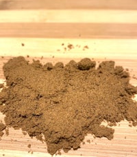 a pile of brown powder on a wooden table