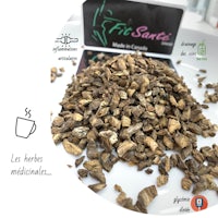 a pile of dried herbs on a table next to a cup of coffee