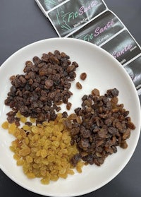 a plate with raisins, nuts, and a bar of soap