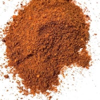 a pile of red chili powder on a white background