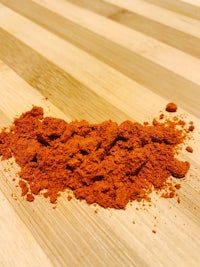 a pile of red powder on a wooden table