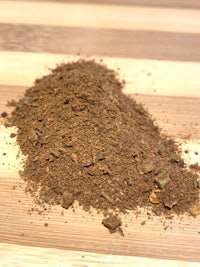 a pile of brown powder on top of a wooden table