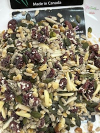 a bowl of dried cranberries, seeds and nuts