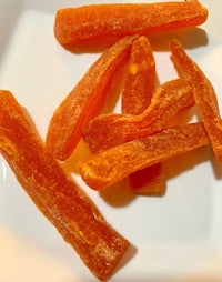 a plate of dried carrots on a white plate