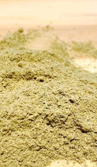 a pile of green powder on a wooden table