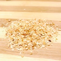 a pile of toasted sesame seeds on a wooden surface