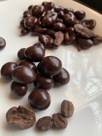 chocolate covered coffee beans on a white plate