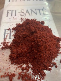 a pile of red powder on top of a piece of paper