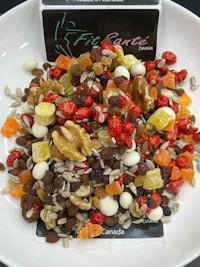 a bowl of mixed fruit and nuts on a table