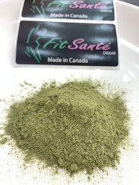 a green powder on a white plate with a label on it