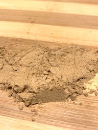 a pile of brown powder on top of a wooden cutting board