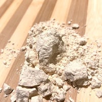 a pile of white powder on a wooden cutting board