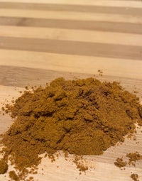 a pile of brown powder on a wooden table