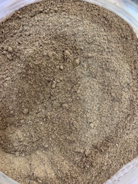 a close up of a brown powder in a glass container