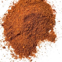 a pile of red chili powder on a white background