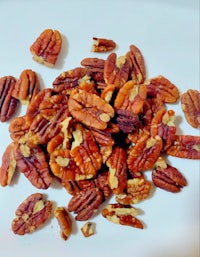 a pile of pecans on a white plate